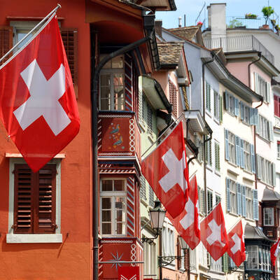 Straße in Zürich mit Fahnen für die Schweizer Nationalfeier geschmückt ©stock.adobe.com_HappyAlex