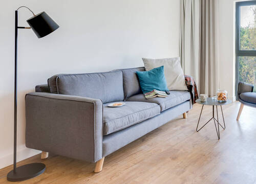 Apartmentansicht mit gemütlichem Sofa im SMARTments business BERLIN KARLSHORST